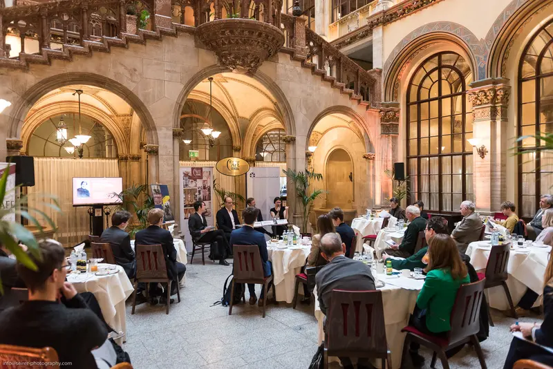 Elegant Conference Gathering in Ornate Historical Interior with Arched Architecture