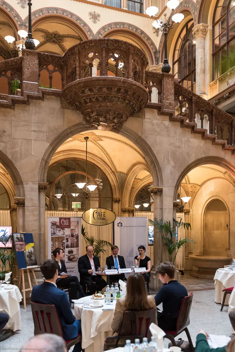 Panel Discussion in Ornate Historic Interior with Elaborate Architectural Detailing