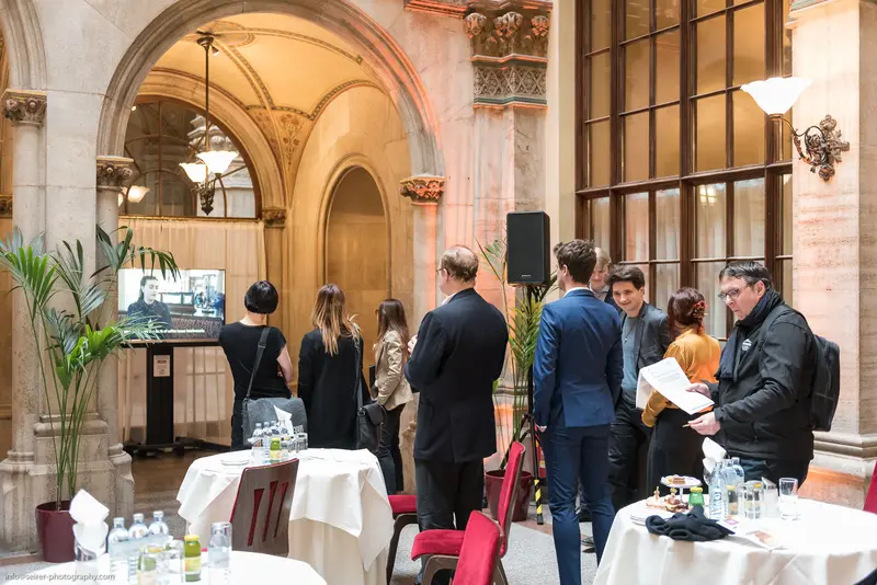 Professional Networking Event in Elegant Architectural Setting with White-Clothed Tables