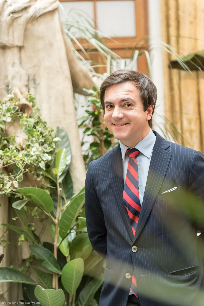 Professional in Pinstripes Standing Amid Botanical Backdrop