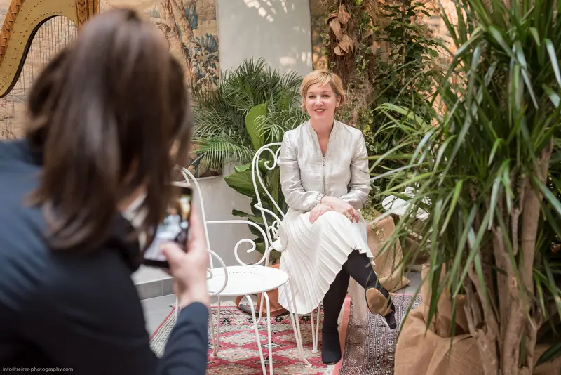 Professional Photoshoot with Woman in White Dress at Elegant Indoor Location
