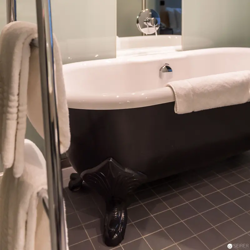 Black and White Modern Bathroom with Luxury Bathtub and Reflective Surfaces
