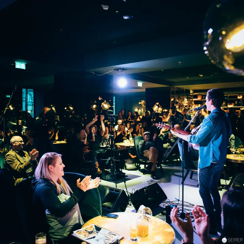 Intimate Live Performance at Dimly Lit Venue with Engaged Audience