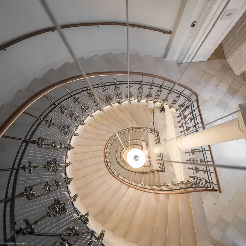 Spiral Staircase Viewed from Above: Architectural Symmetry and Ornate Metalwork