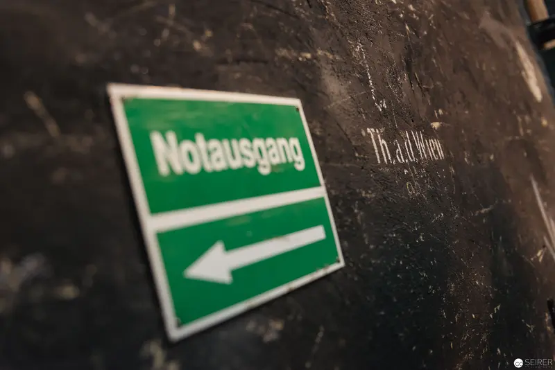 Emergency Exit Sign in Industrial Setting with Directional Arrow