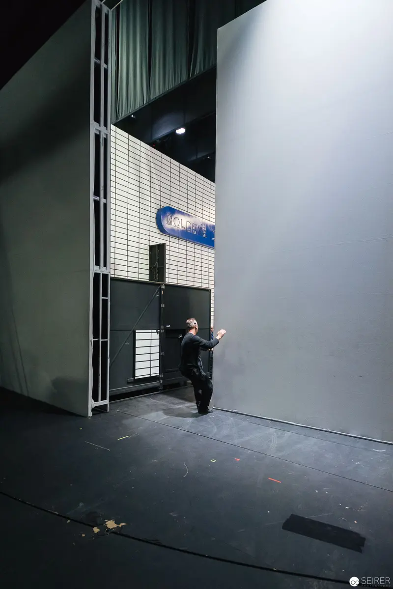 Lone Figure in Dramatic Stage Lighting at Minimalist Performance Space