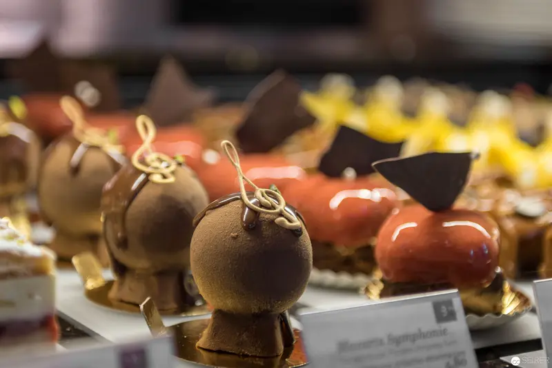 Glossy Spherical Chocolate Desserts with Decorative Gold Treble Clef Ornaments