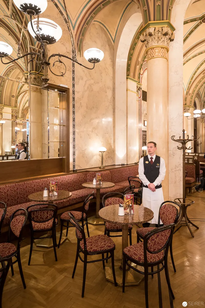 Café Central's Elegant Interior with Attentive Staff in Historic Viennese Setting
