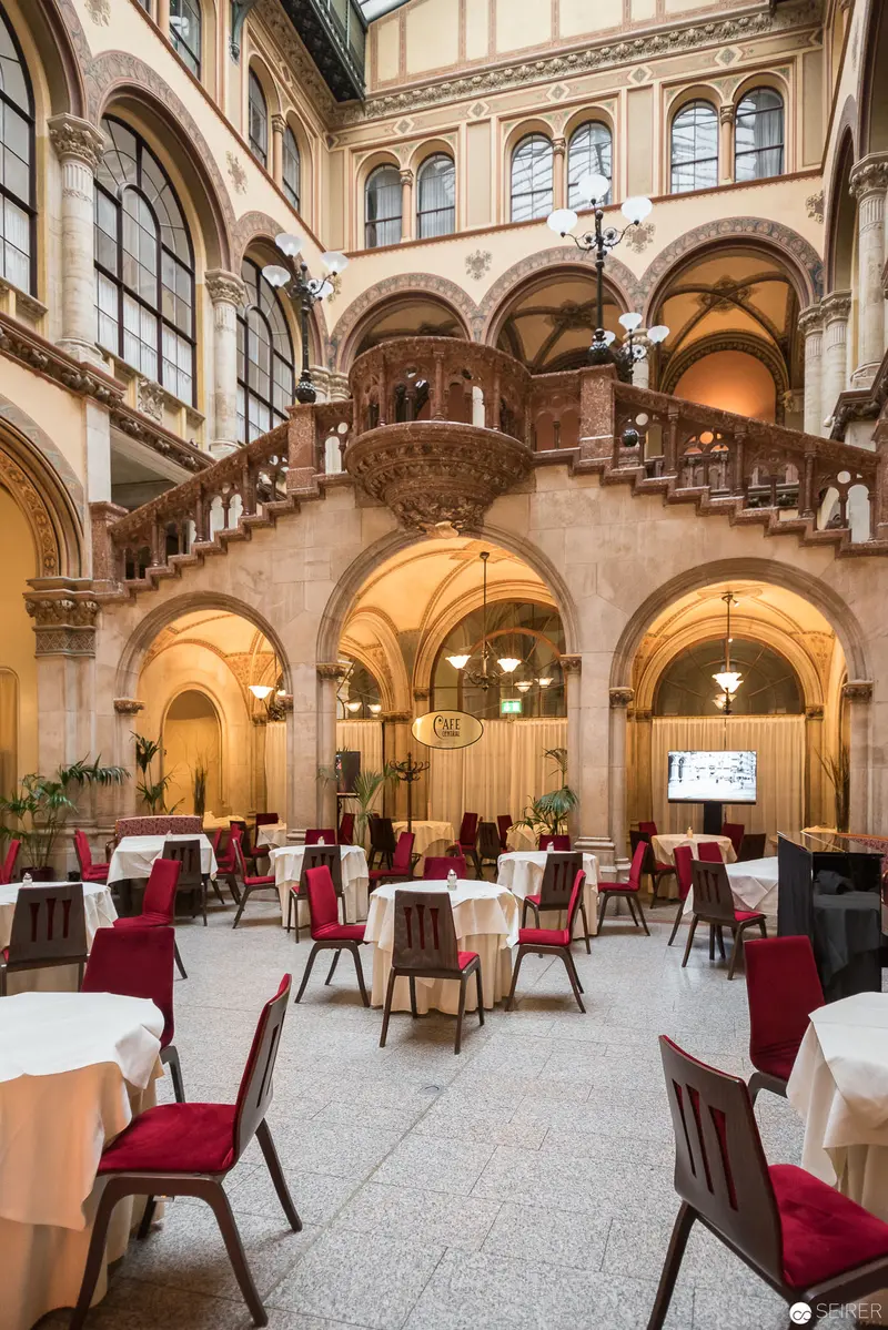 Café Central's Elegant Interior: Baroque Arches and Crimson Seating in Vienna