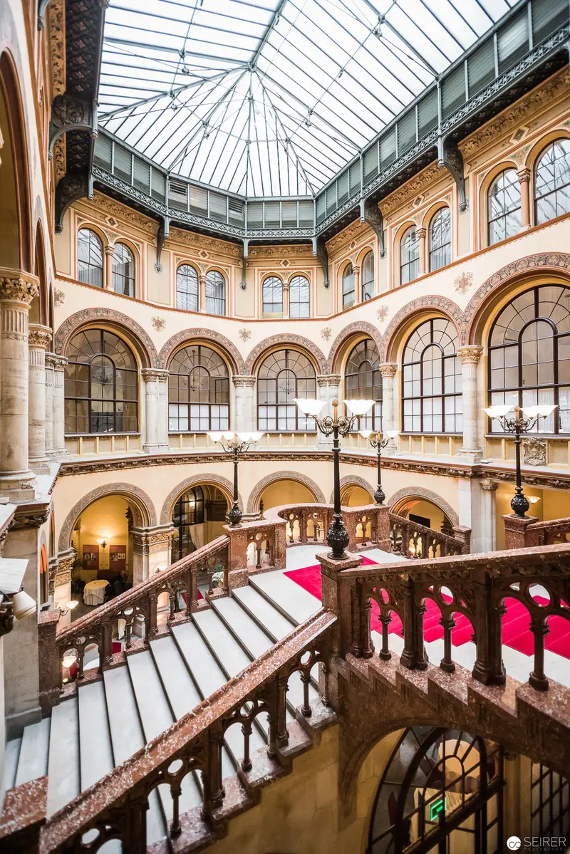 Grand Interior of Café Central: Architectural Splendor with Arched Windows and Glass Ceiling