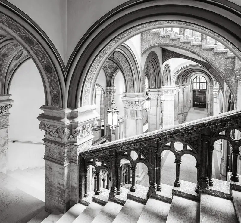 Intricate Gothic Revival Interior: Architectural Arches and Ornate Staircase in Monochrome