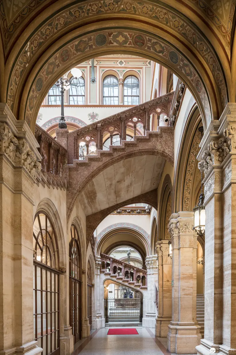 Ornate Architectural Interior with Intricate Archways and Sweeping Curved Staircase