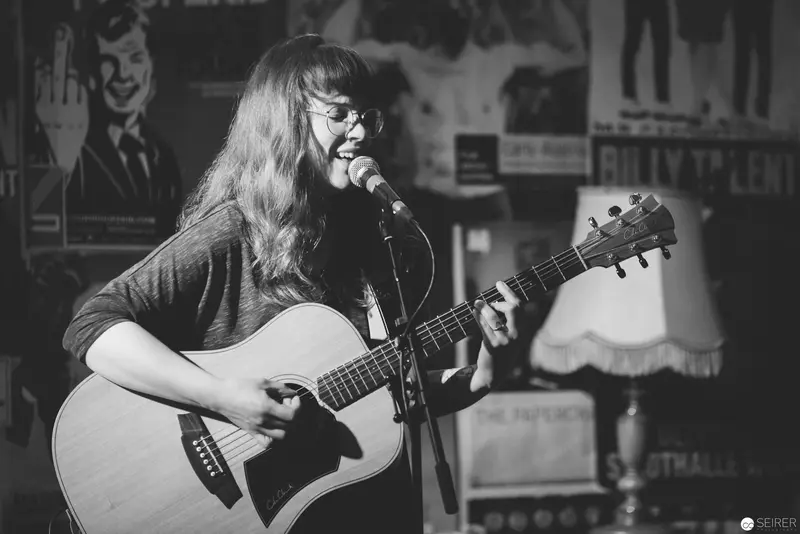 Black and White Portrait of Acoustic Guitarist Performing at Intimate Venue