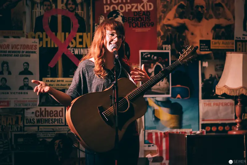 Acoustic Performer in Vintage Poster-Lined Performance Space