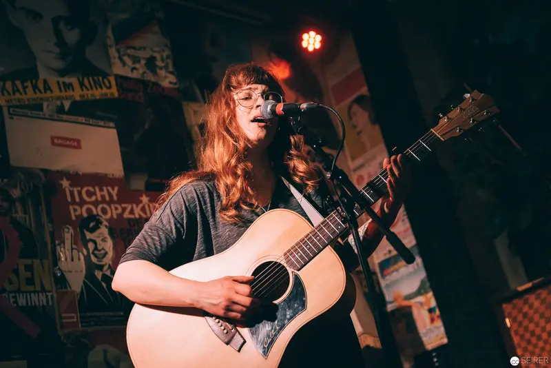 Singer-Songwriter Performing Acoustic Guitar at Intimate Music Venue
