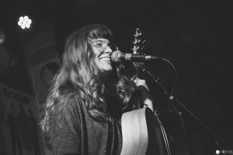 Emotive Performer Singing into Microphone in Monochrome Stage Lighting