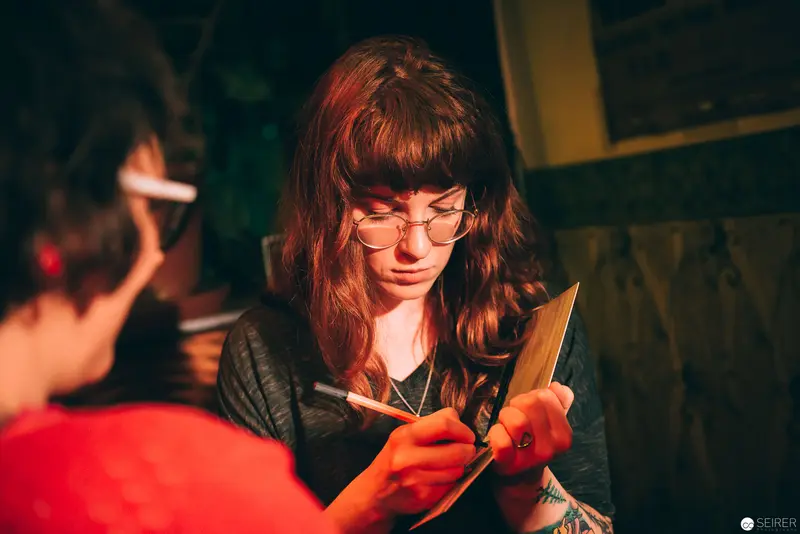 Concentrated Artist Working Intently with Precise Cutting Tool in Low Light