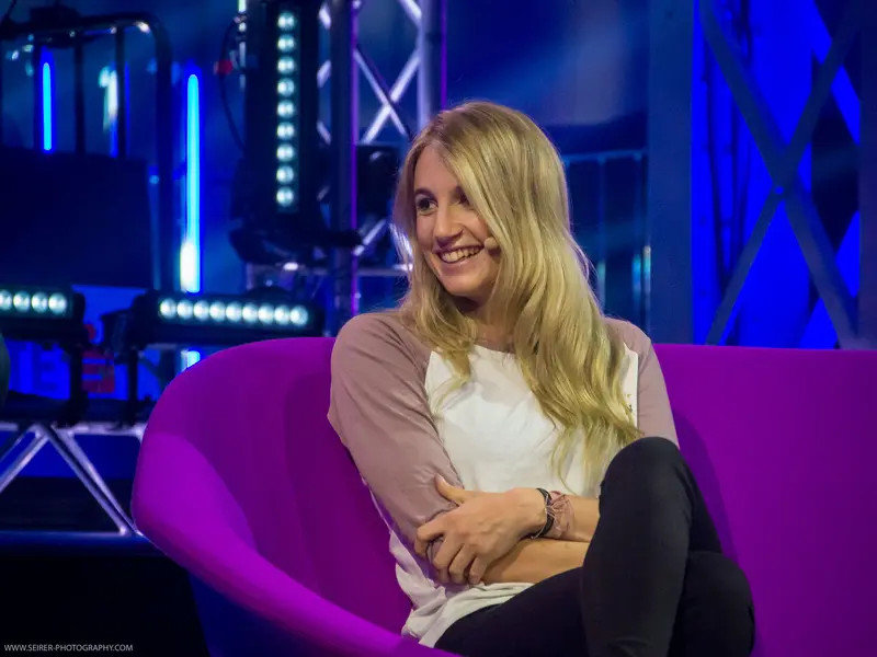 Blonde Speaker at 4GameChangers Festival Seated on Vibrant Purple Chair