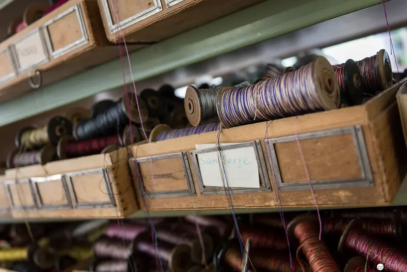 Archival Thread Collection: Vintage Wooden Shelves with Multicolored Textile Spools
