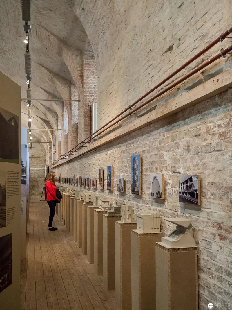 Art Gallery Interior with Pedestals and Photographic Exhibition Along Brick Wall