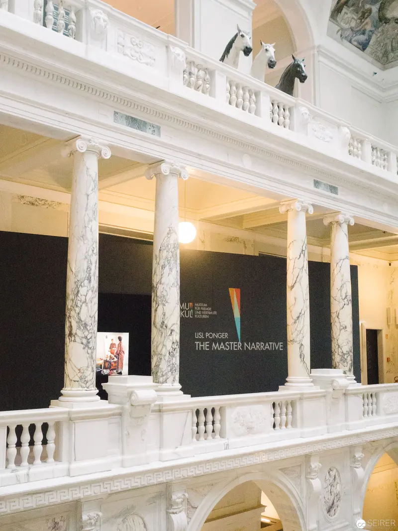 The Master Narrative Exhibition: Architectural Interior with Marble Columns and Exhibition Signage
