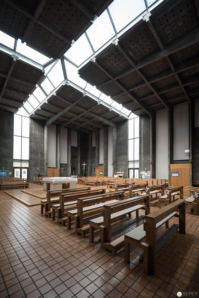 Modern Church Interior at Pfarre Oberbaumgarten with Geometric Skylights and Wooden Benches