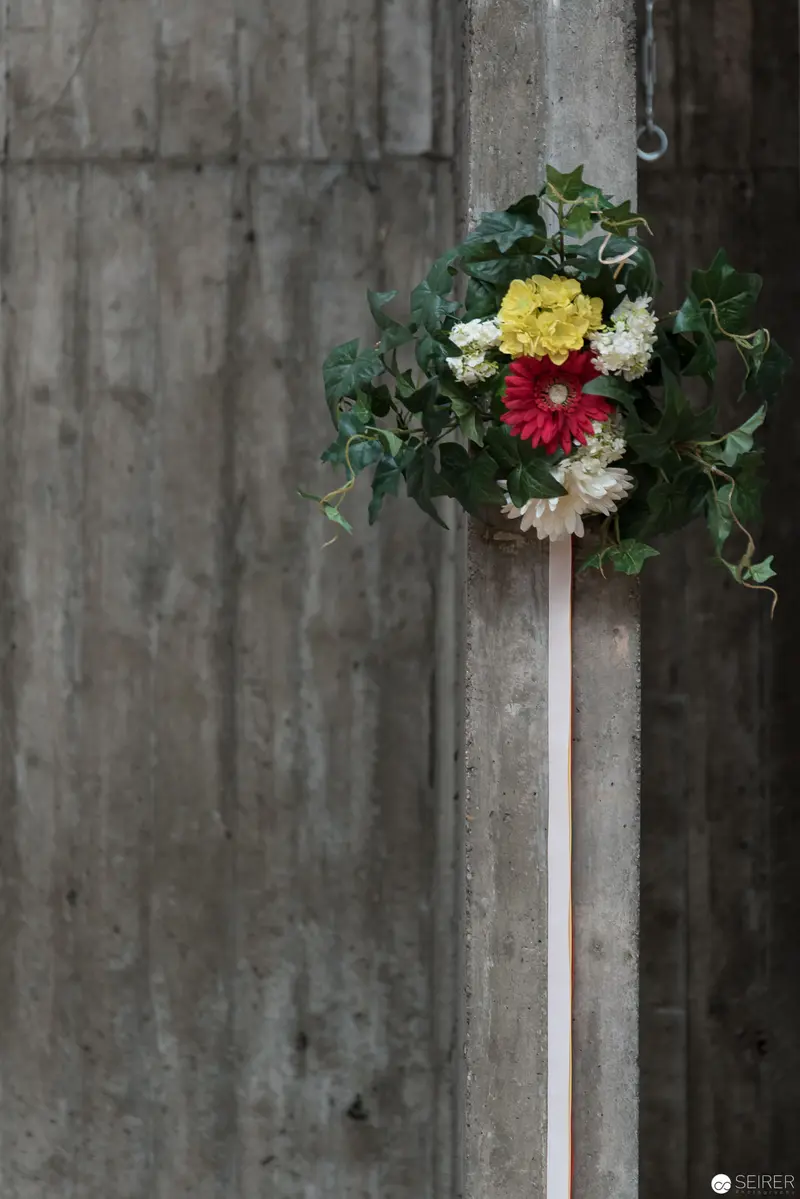 Floral Memorial Arrangement Adorning Weathered Concrete Architectural Surface