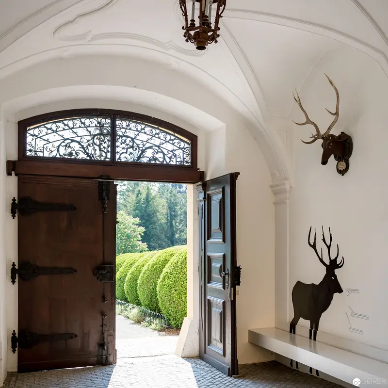 Elegant Entryway with Deer Silhouettes and Ornate Arched Architecture