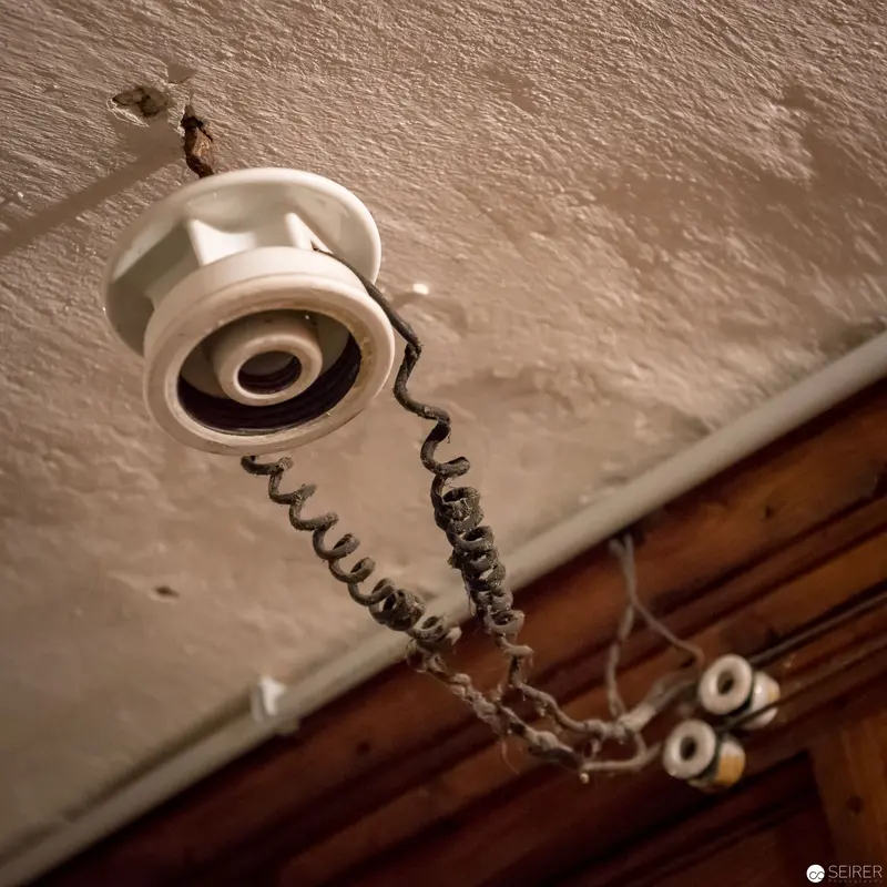 Vintage Intercom with Coiled Cord Mounted on Textured Ceiling