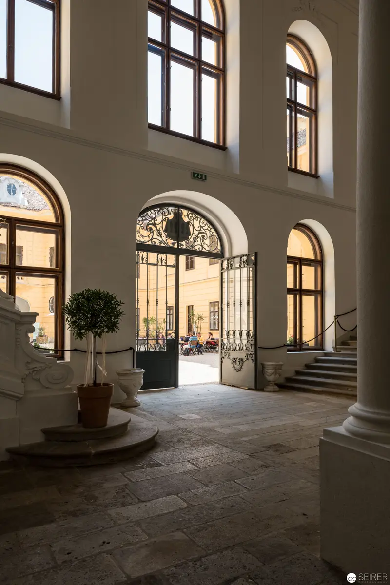 Ornate Entrance Hall of Schloss Eckartsau with Arched Windows and Decorative Gate