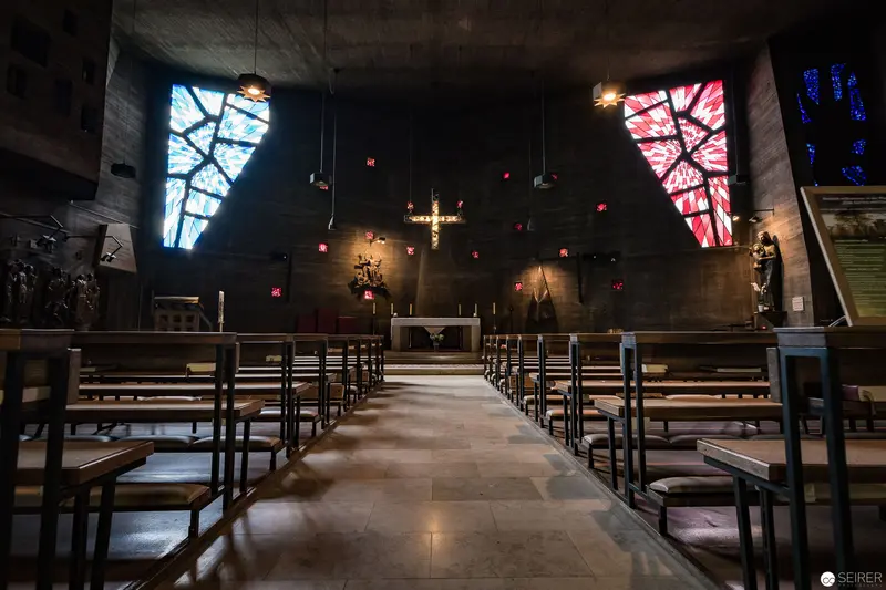 Interior of Pfarre zum guten Hirten: Modernist Church Architecture with Stained Glass Illumination