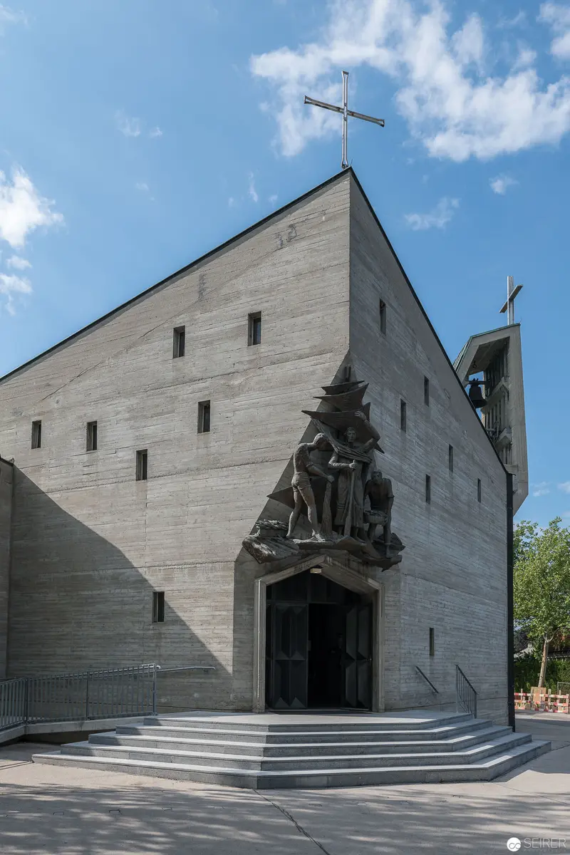 Modern Concrete Church Exterior with Sculptural Religious Figure at Entrance