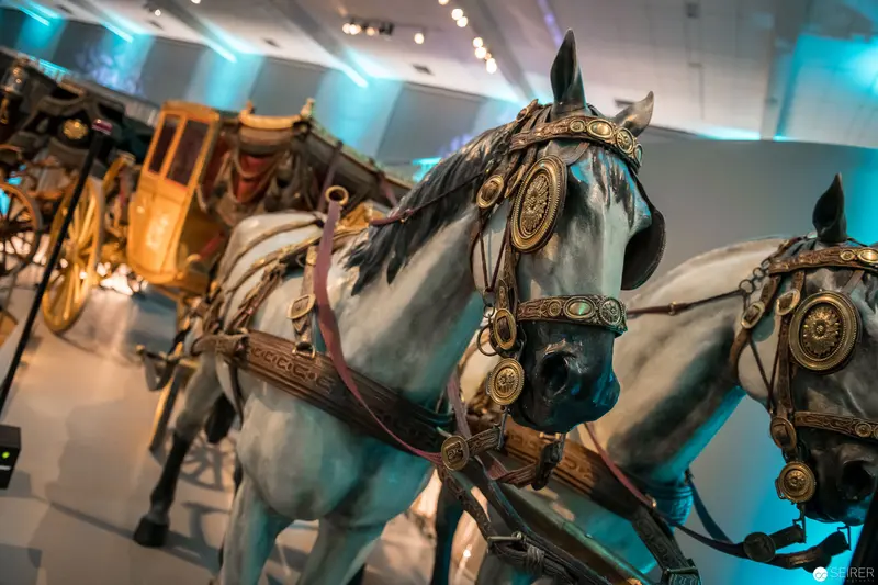 Ornate Imperial Horse Statues in Museum Display with Ceremonial Carriage