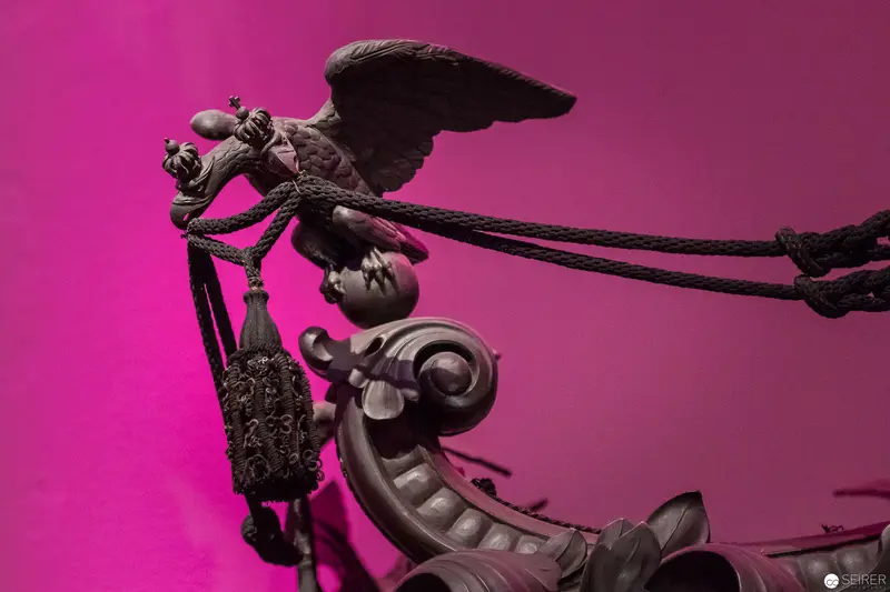 Ornate Maritime Sculpture Against Vibrant Magenta Background