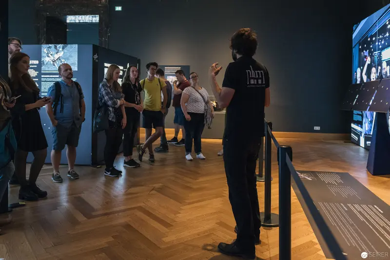 Asteroid Day Exhibition Visitors Engaged with Interactive Museum Display