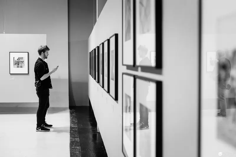 Solitary Viewer Examining Framed Photographs in Minimalist Gallery Space