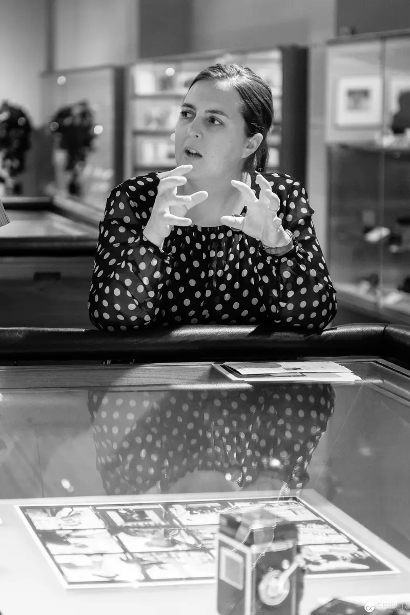 Woman in Polka Dot Blouse Contemplating at Office Display Case