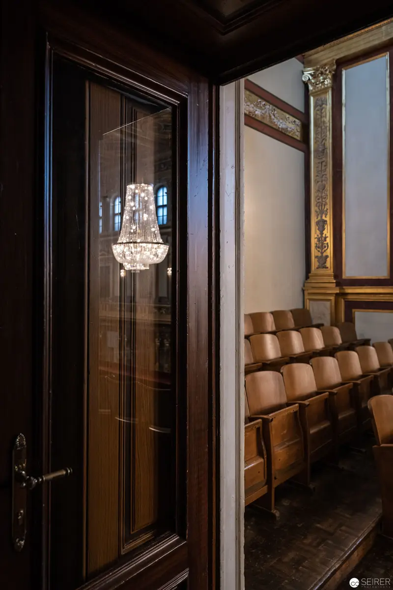Interior View of Musikverein Concert Hall with Ornate Crystal Chandelier and Wooden Seating