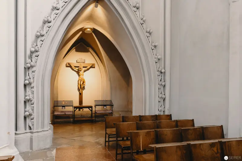 Interior of Gothic-Arched Church Chapel with Crucifix and Wooden Pews