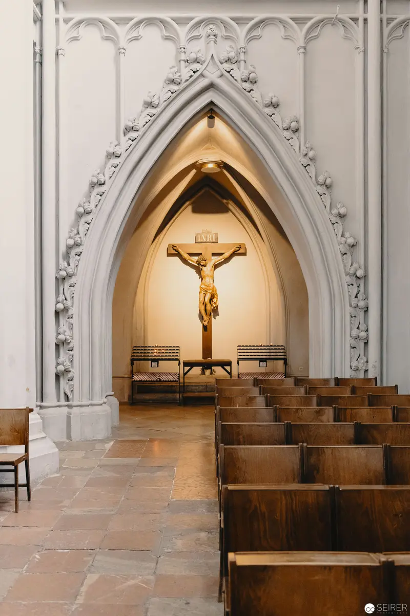 Gothic Chapel Interior with Crucifix and Wooden Pews in Contemplative Lighting