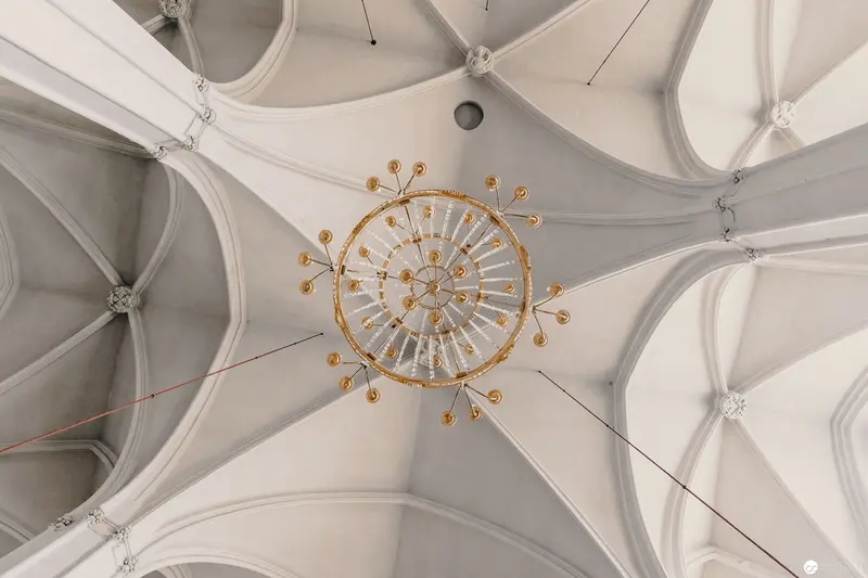 Gothic Vaulted Ceiling with Ornate Golden Chandelier in White Architectural Space