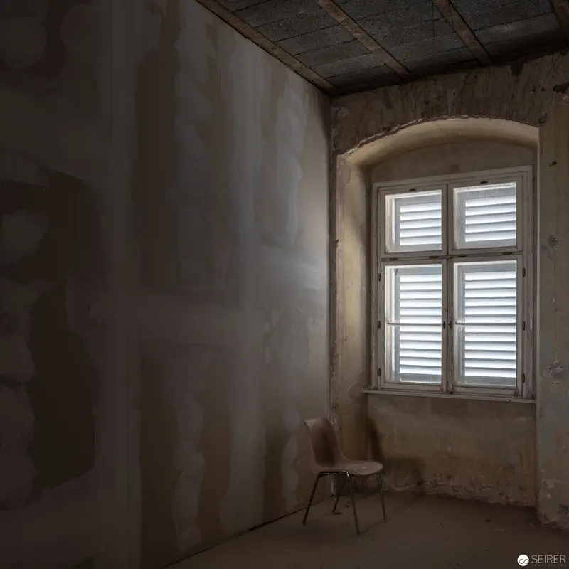 Solitary Chair by Arched Window in Abandoned Interior