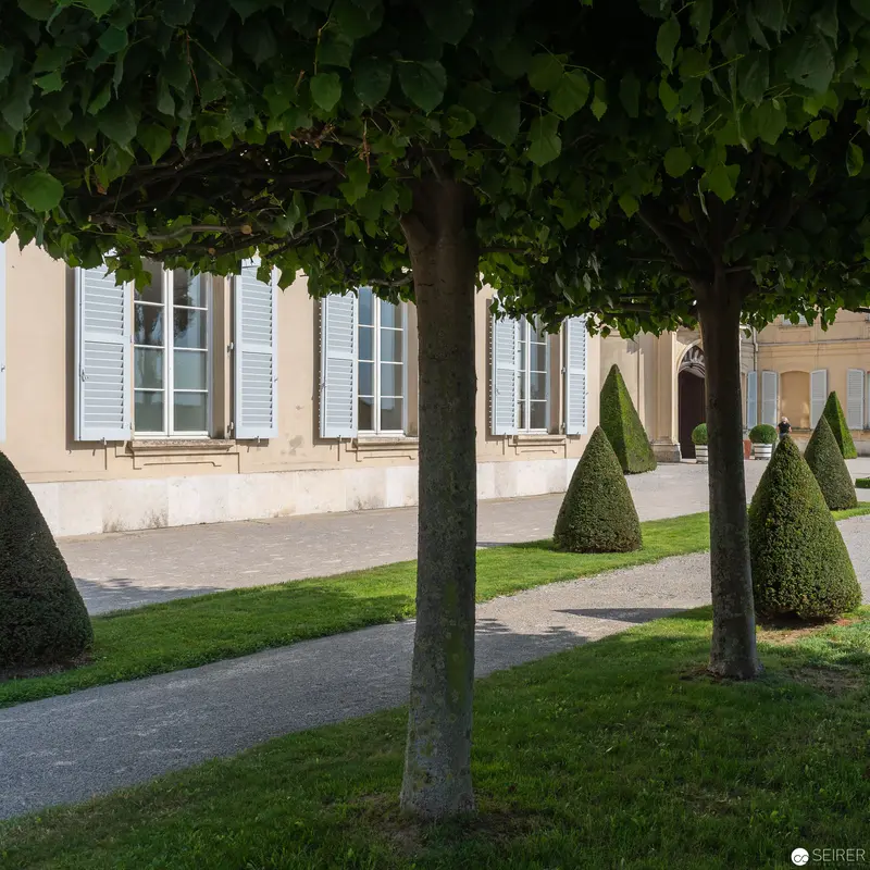 Formal French Garden with Manicured Trees and Architectural Facade