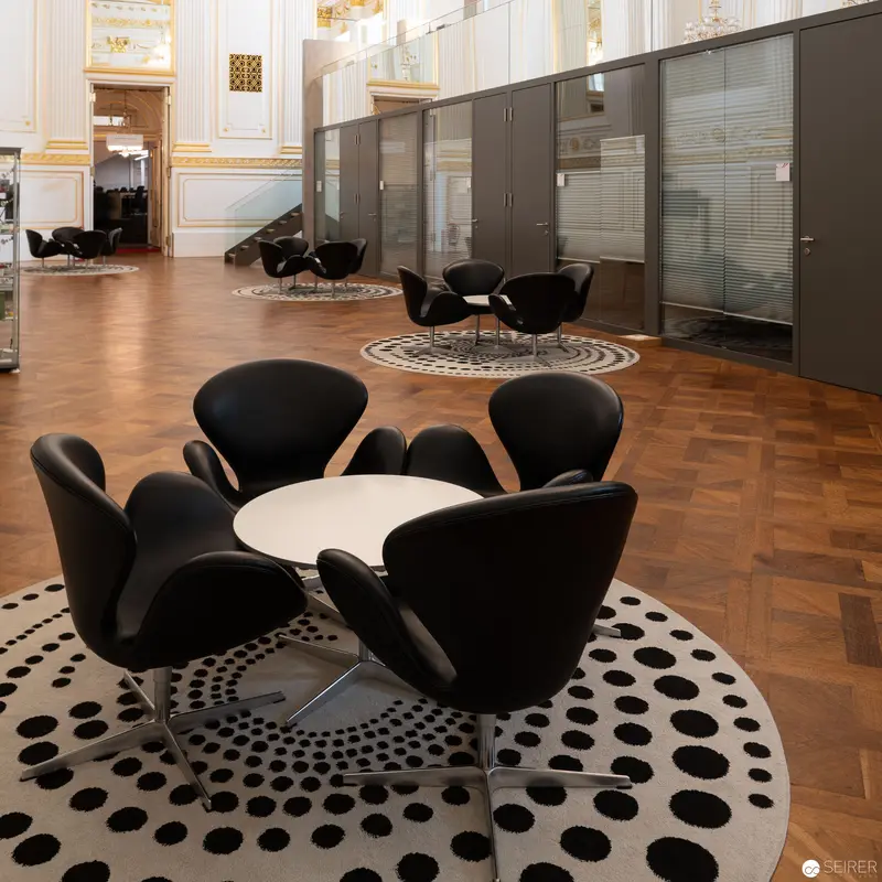 Modern Office Interior with Black Swan Chairs on Patterned Circular Rugs