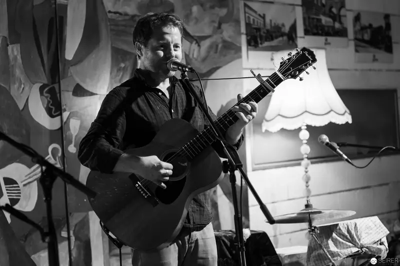 Solo Acoustic Performance in Intimate Black and White Studio Setting