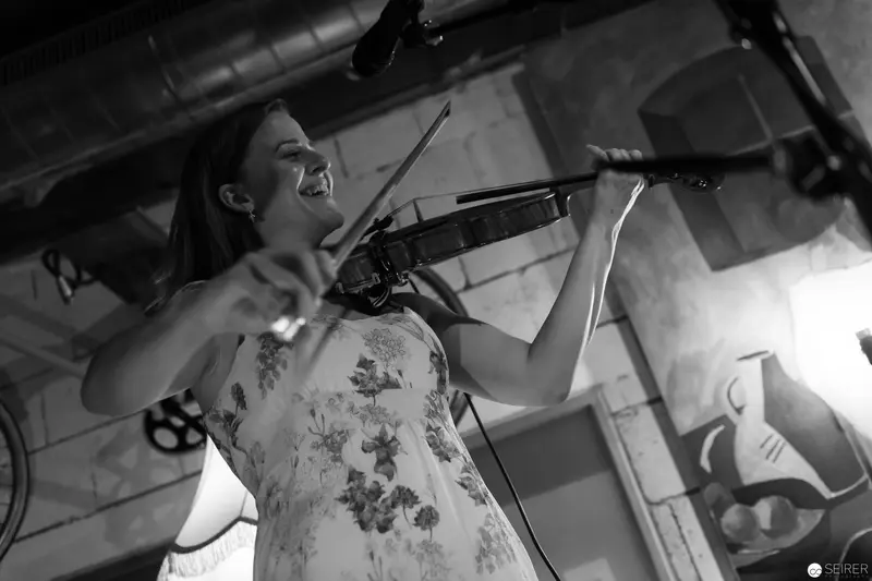 Violinist in Floral Dress Performing with Intense Expression in Black and White