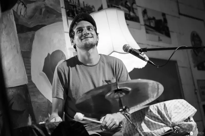 Drummer Performing with Joyful Expression at Intimate Musical Venue