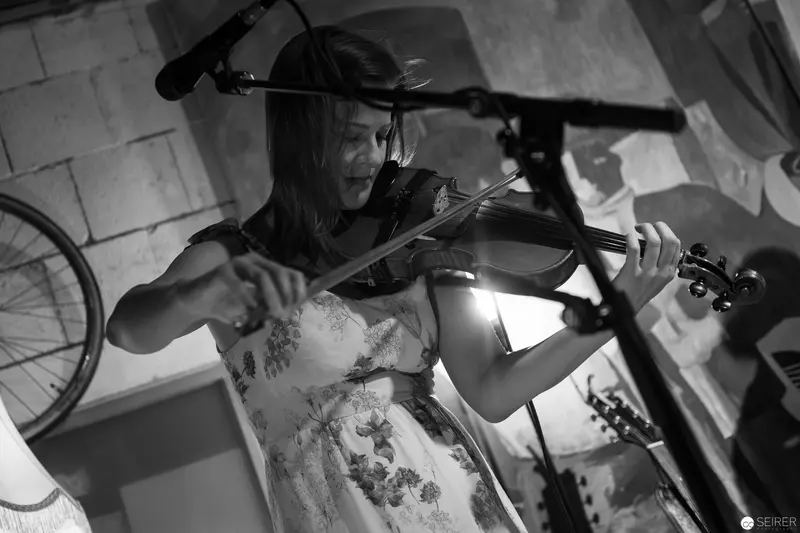 Violinist in Monochrome Performance with Dramatic Studio Lighting and Bicycle Wheel