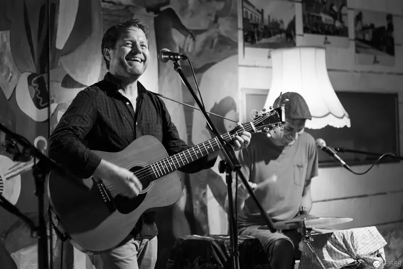 Acoustic Performer Laughing During Intimate Live Music Performance
