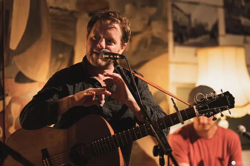 Intimate Acoustic Performance with Guitarist at Warm-Lit Venue